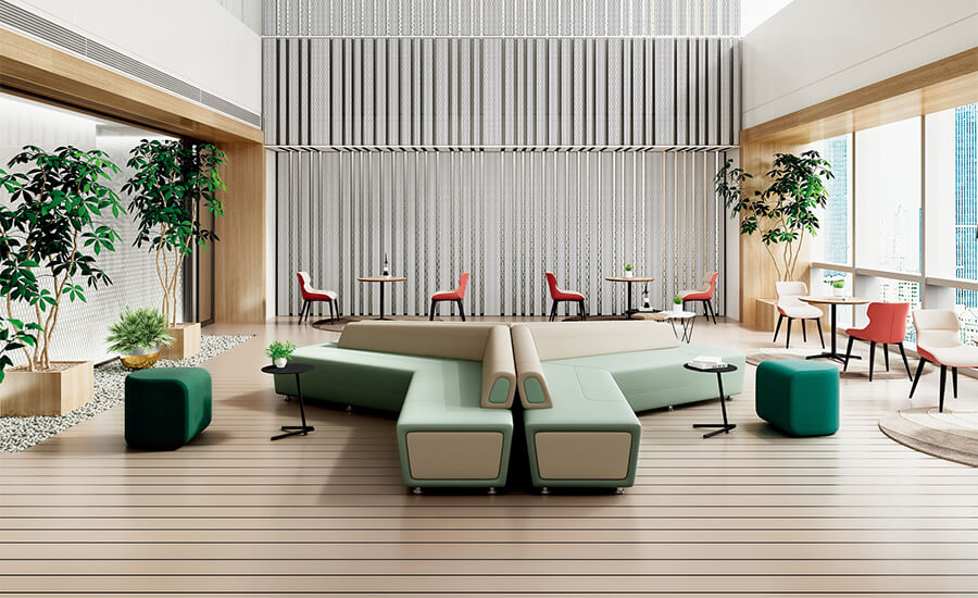 Dos sofás lounge con cojines verdes junto a una pequeña mesa de café y un taburete lounge en un área pública.